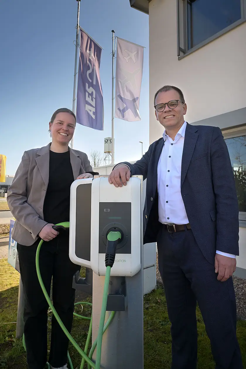 Ann-Kristin Ciminski (links) und Staatsrat Jan Fries (rechts) an einer der zahlreichen Wallboxen der AES Aircraft Elektro/Elektronik System GmbH
