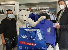 Foto: Barmak Ghotby von der Waschbär-Reinigung und Dr. Mathias Grabs aus dem Umweltressort setzen ab sofort auf Mehrwegschutzhüllen statt Plastikfolie.