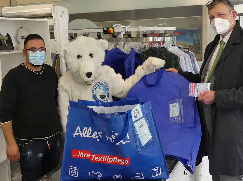 Foto: Barmak Ghotby von der Waschbär-Reinigung und Dr. Mathias Grabs aus dem Umweltressort setzen ab sofort auf Mehrwegschutzhüllen statt Plastikfolie.