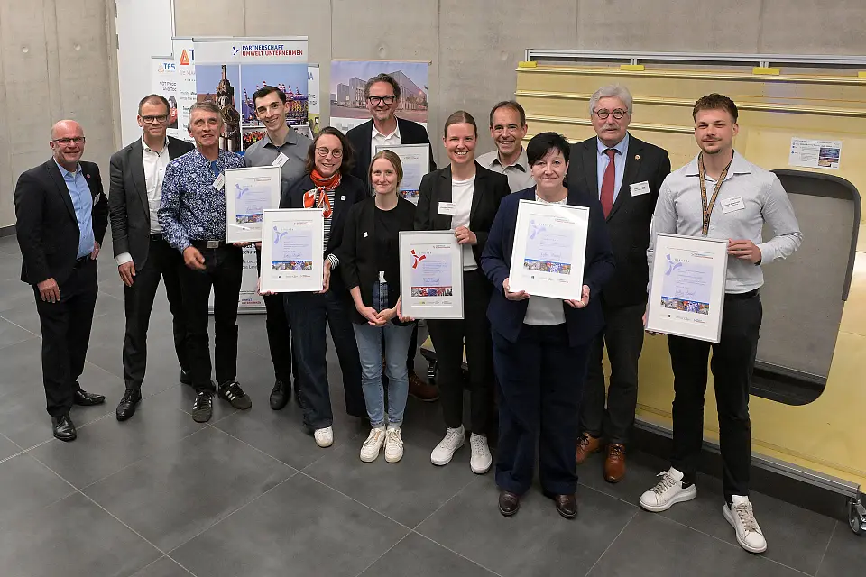 Vertreter:innen und Vertreter der fünf neuen Mitgliedsunternehmen und des ausgezeichneten Klimaschutzbetriebs mit Staatsrat Jan Fries (2.l.) und Martin Schulze (links im Bild) von der Geschäftsstelle Umwelt Unternehmen.