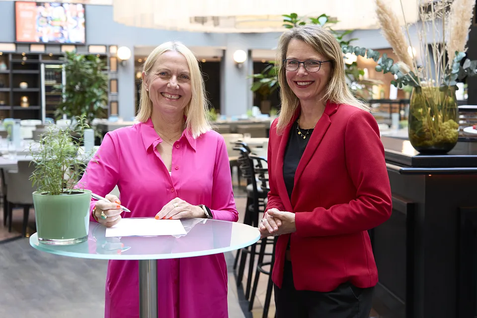 Angelika Zupanc, Direktorin des Radisson Blu Hotel Bremen, unterzeichnet im Beisein von Dr. Diana Wehlau aus dem Umweltressort (rechts im Bild) die Rahmenvereinbarung zum Beitritt in die Umweltpartnerschaft.