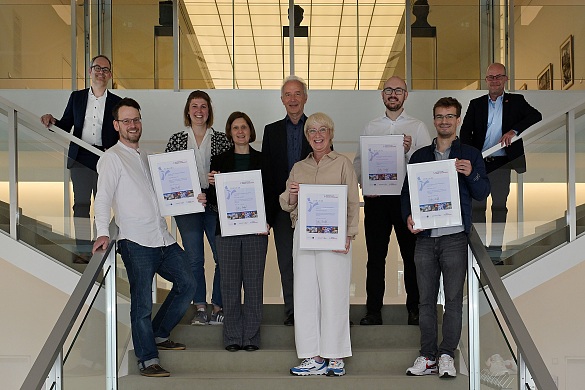 Gruppenfoto der neuen Mitglieder mit den unterzeichneten Mitgliedschaftsurkunden in der Bremischen Bürgerschaft.