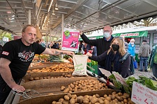 Bild der Umwelt- und Klimaschutzsenatorin Dr. Maike Schaefer, die am Stand von Landwirt Carsten Gerken Kartoffeln in einem Mehrweg-Beutel kauft.