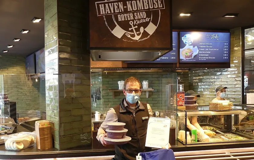 Bild des Geschäftsführers Jens Knauer mit den Mehrweglösungen für den Takeaway-Verkauf.