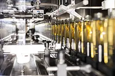 Eine Produktionsanlage der Walter Lang GmbH füllt in einer Reihe Flaschen ab.