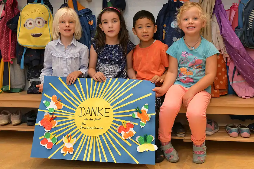 Foto von vier Kindern mit selbstgemaltem Bild