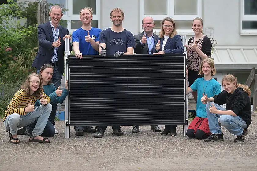 V.l.n.r unten: Die Schüler Elias, Finn, Fiete und Jonte.  V.l.n.r. oben: Martin Grocholl, Geschäftsführer energiekonsens, Christian Gutsche, Gründer Bremer SolidarStrom, Mathias de Riese, engagiertes Elternteil, Martin Schulze, Leiter Geschäftsstelle Umwelt Unternehmen, Dr. Diana Wehlau, Abteilungsleiterin bei der Senatorin für Umwelt, Klima und Wissenschaft, und Laura Treptow, Schulleiterin der Freien Gemeinschaftsschule Bremen, mit einem von insgesamt vier durch den Bremer Klimafonds finanzierten Solarmodulen.