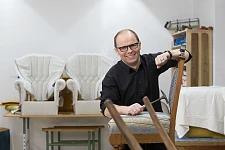 Mann mit Hammer und Stuhl