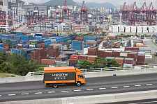 Kleintransporter mit Containerhaven im Hintergrund