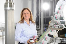 Frau mit Gläsern in der Hand hinter Maschine