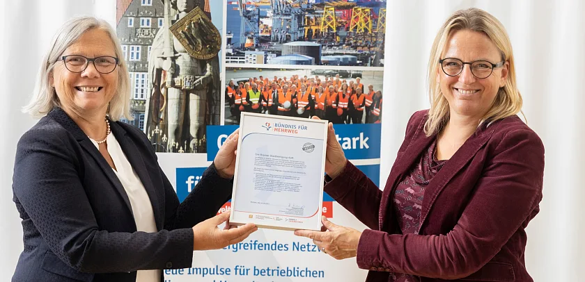 Zwei Personen bei der Urkundenübergabe